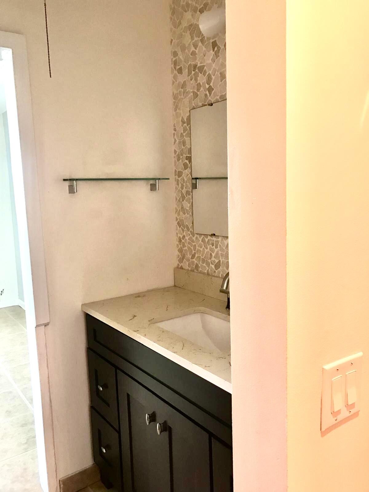 1439 South Ocean Boulevard, Unit 303 Lauderdale-by-the-Sea, FL 33062 - Photo 24 of 31 a bathroom with a sink and a mirror