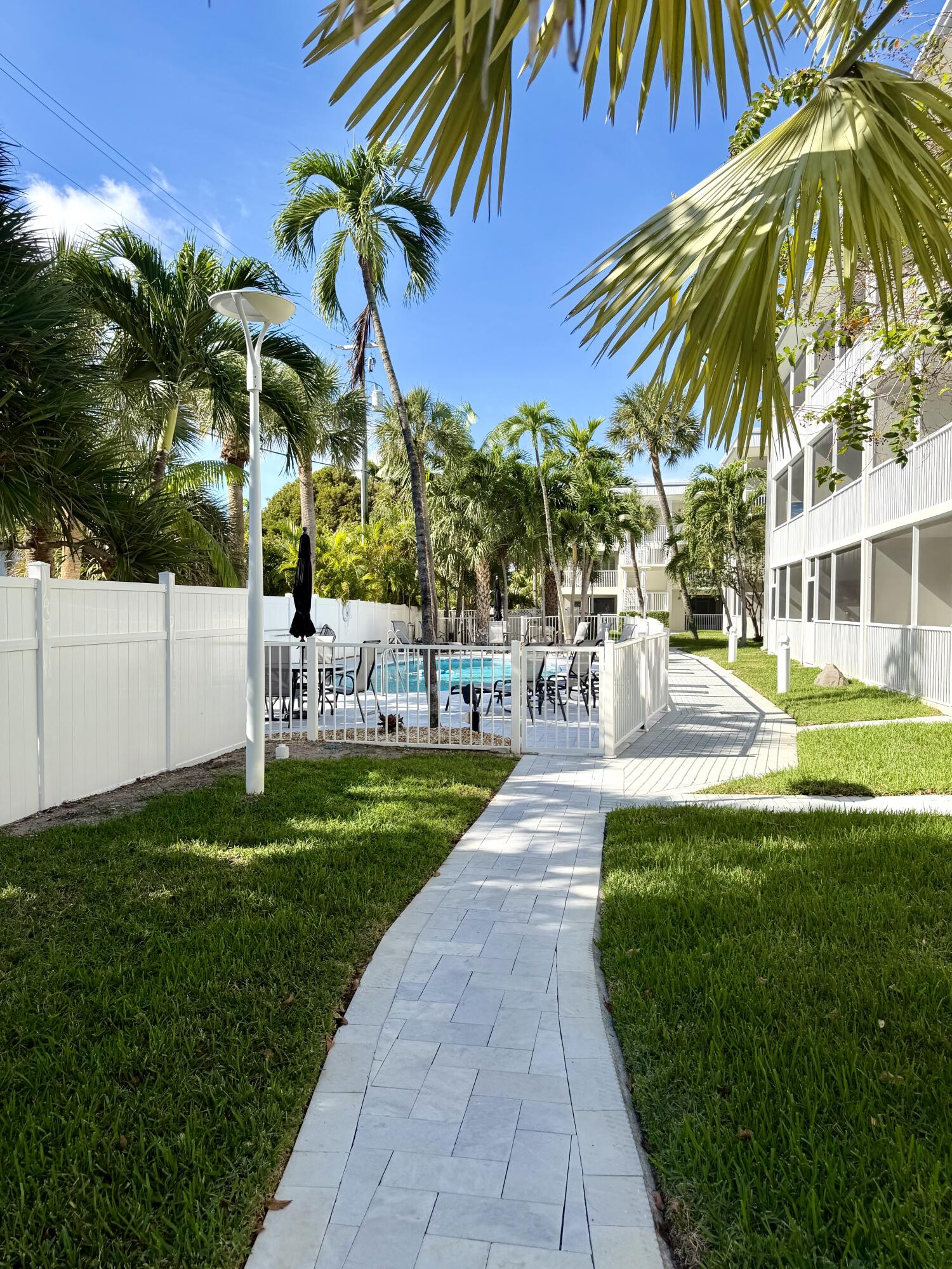 1439 South Ocean Boulevard, Unit 303 Lauderdale-by-the-Sea, FL 33062 - Photo 5 of 31 a view of a swimming pool with a garden and trees