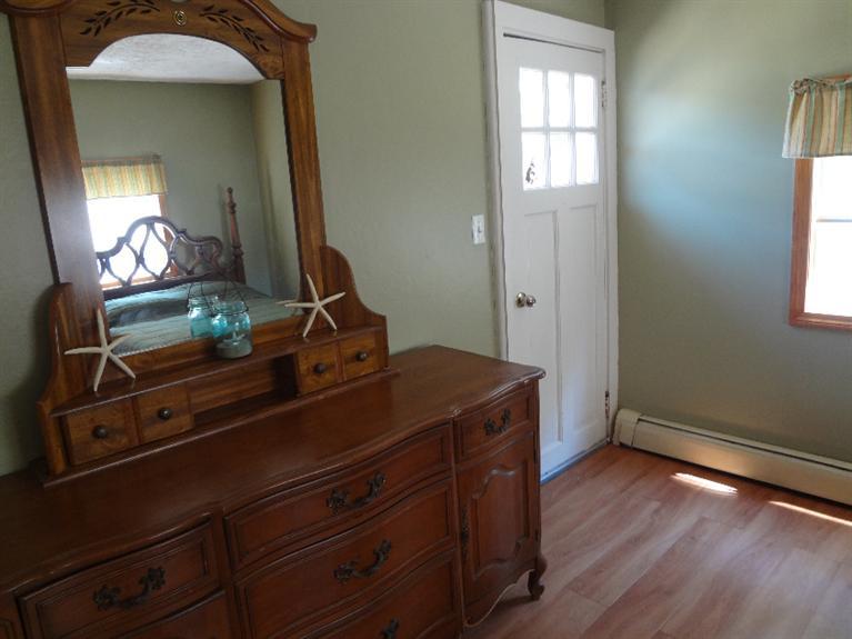 138 Spring Street Hyannis, MA 02601 - Photo 10 of 12 a room with a mirror and a wooden floor