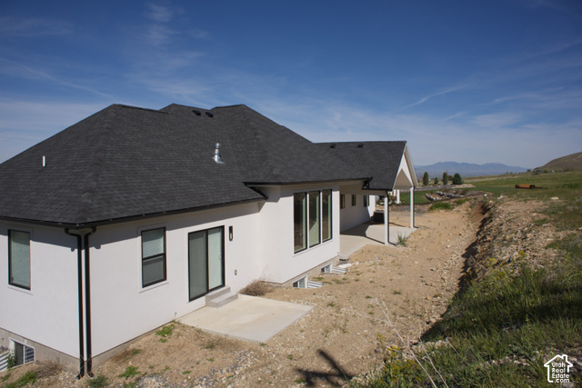 3504 North Sun Dancer Loop Logan, UT 84341 - Photo 57 of 59 White exterior with dark roof shingles, black-framed windows, and a covered patio