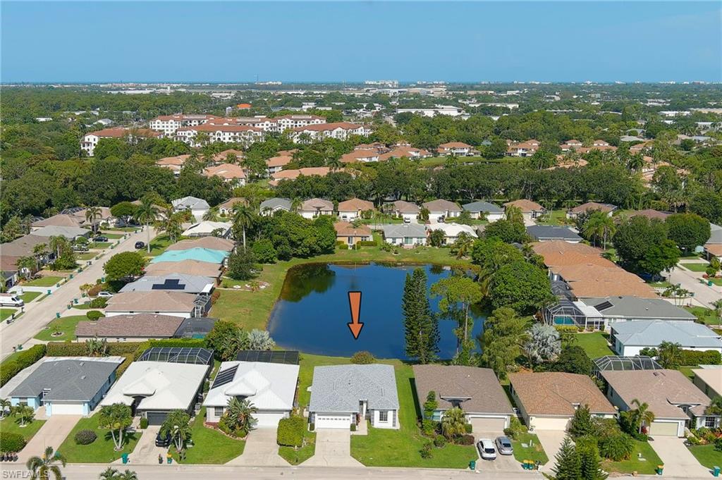 223 Stanhope Circle Naples, FL 34104 - Photo 30 of 41 Aerial perspective showcasing a residential community with a central pond