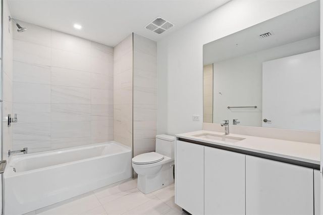 a bathroom with a bathtub shower sink vanity and toilet