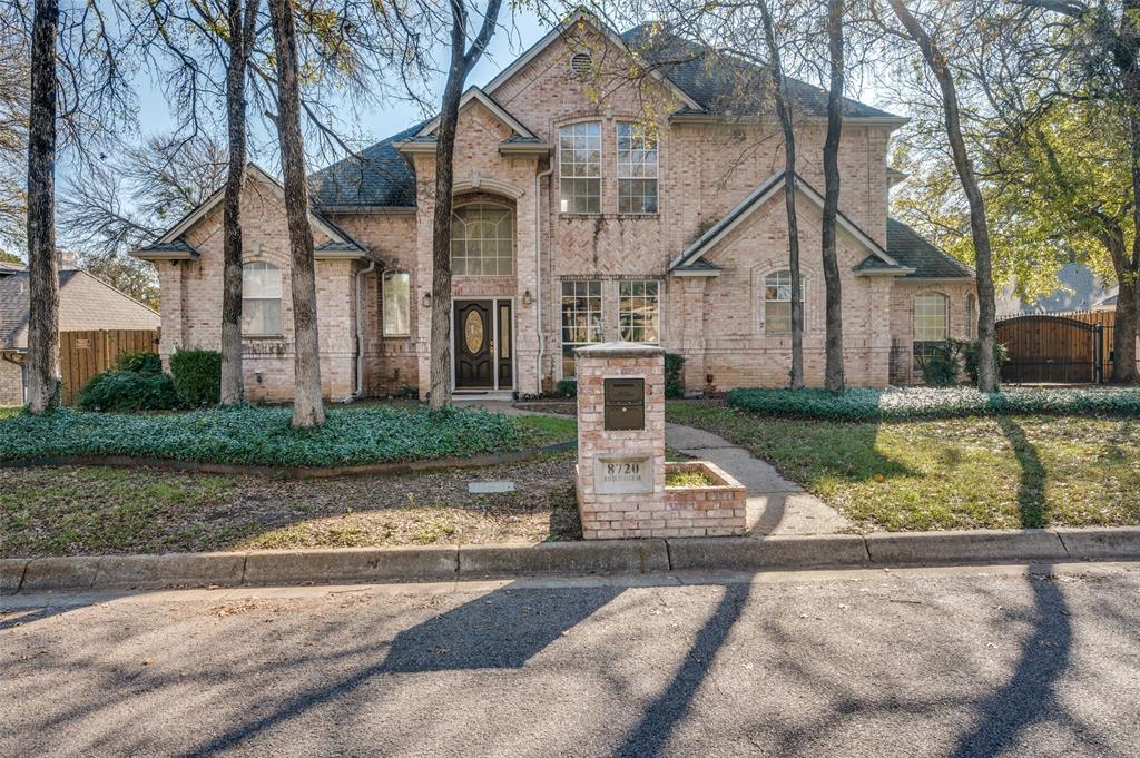 View of front of house with brick siding, a fenced front yard, and a gate