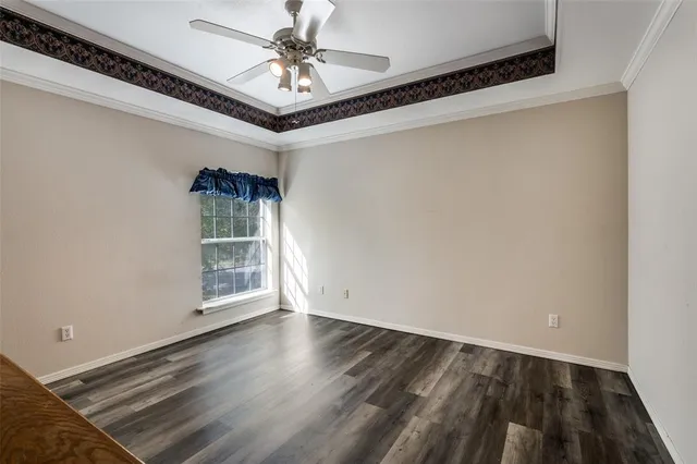 en empty room with wooden floor and ceiling fan