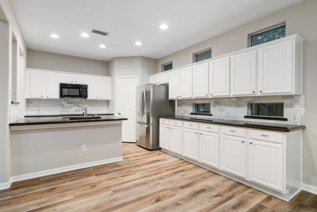 a kitchen with stainless steel appliances granite countertop a stove a sink and a refrigerator