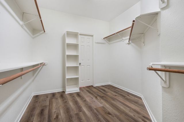 a view of walk in closet with empty racks