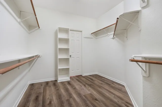 a view of walk in closet with empty racks