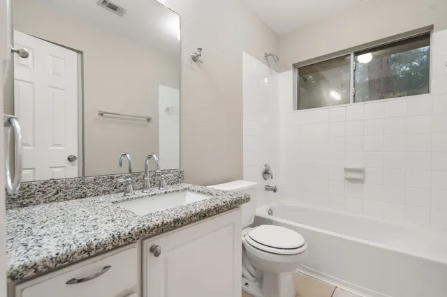 a bathroom with a granite countertop sink toilet and shower
