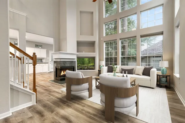 a living room with fireplace furniture and a large window