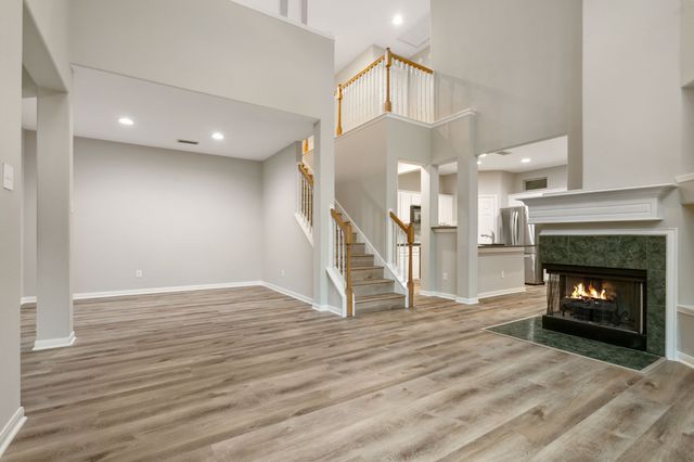 a view of a livingroom with wooden floor and a fireplace