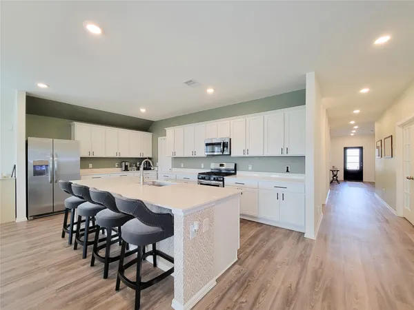 a kitchen with white cabinets and stainless steel appliances