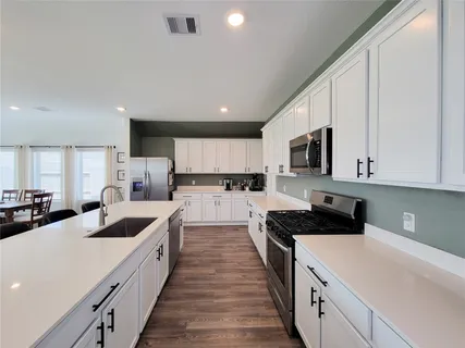 a kitchen with counter top space a sink a stove and refrigerator