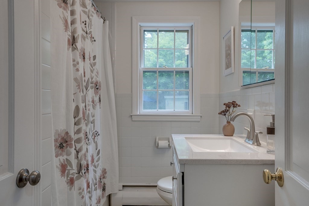 11 Avalon Road Reading, MA 01867 - Photo 27 of 31 a bathroom with a sink a toilet and a mirror