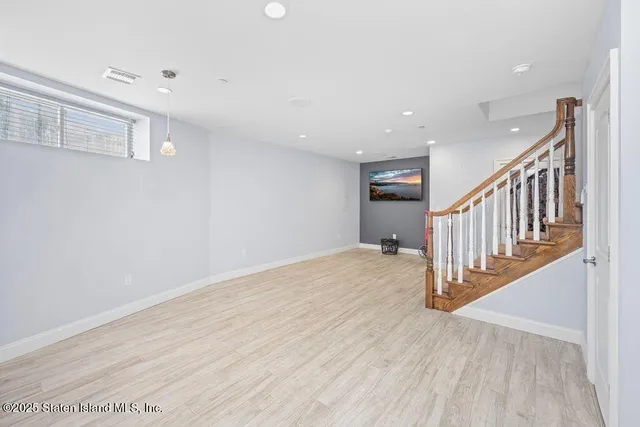 a view of a hallway with wooden floor and entryway