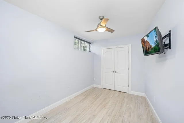 a view of a room with wooden floor and ceiling fan