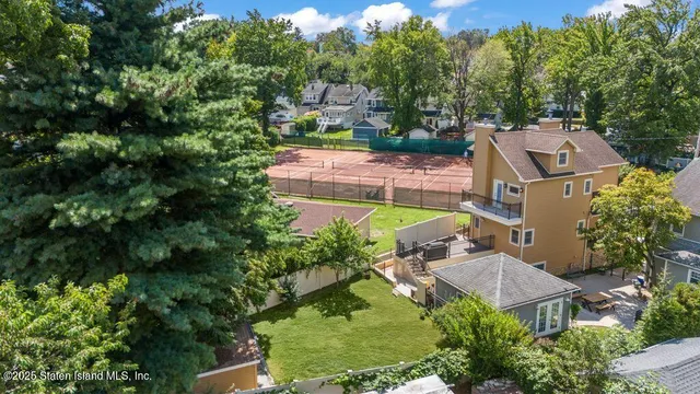 an aerial view of a house with a yard and lake view