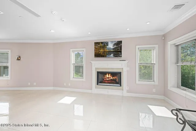 a view of an empty room with a window and a fireplace