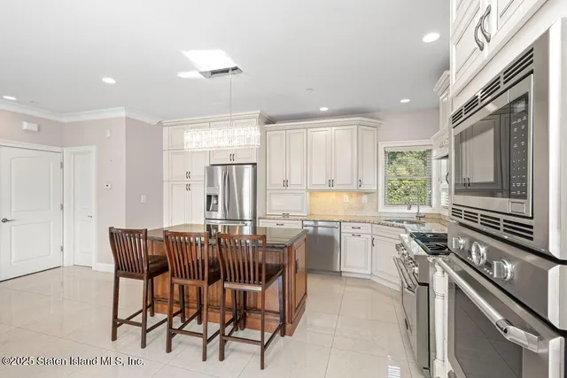 a kitchen with a table chairs microwave and cabinets