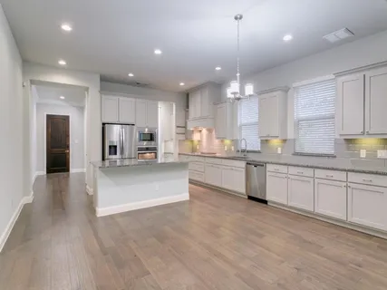 a large kitchen with granite countertop a large counter top stainless steel appliances and cabinets