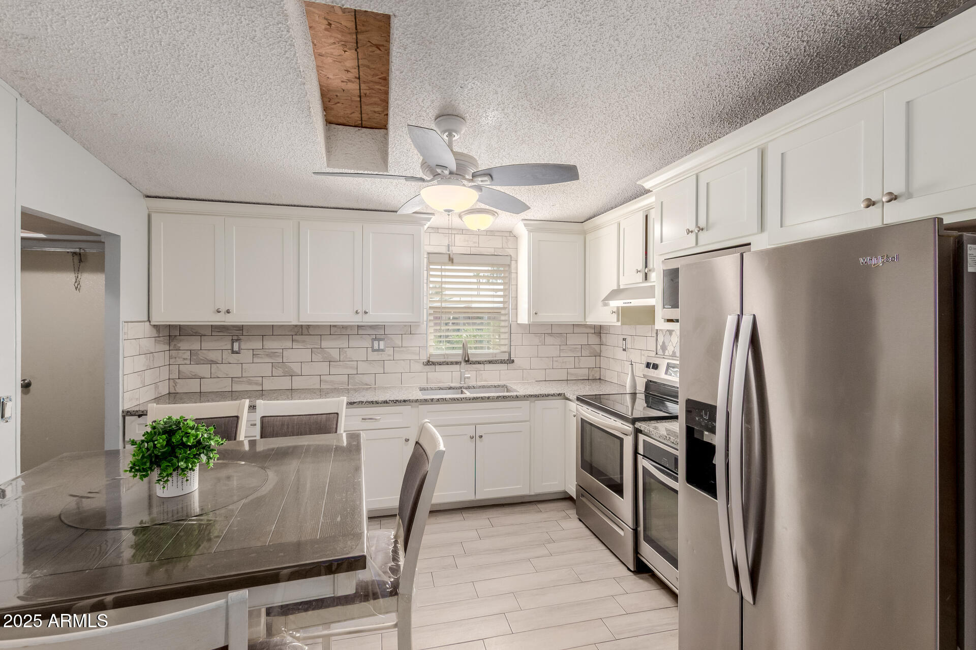 555 West Warner Road, Unit 139 Chandler, AZ 85225 - Photo 5 of 21 a kitchen with granite countertop a refrigerator a stove a sink a counter space and cabinets