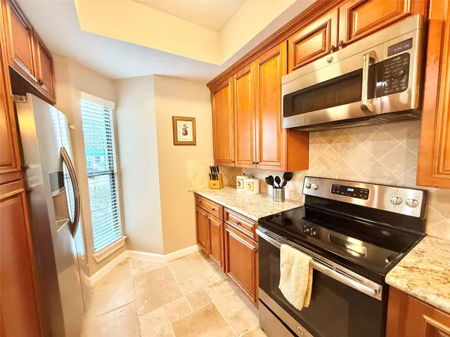 a kitchen with granite countertop a sink a counter top space and cabinets