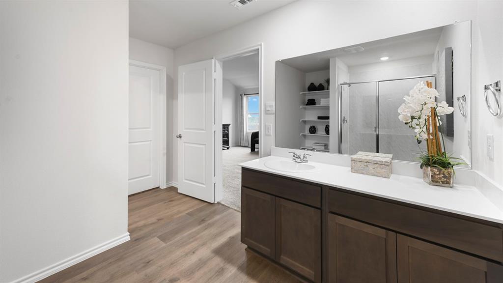 1671 Mantle Road Crandall, TX 75114 - Photo 16 of 24 Bathroom vanity with a single basin sink and white countertop, dark wood-finish cabinetry, and a large wall-mounted mirror