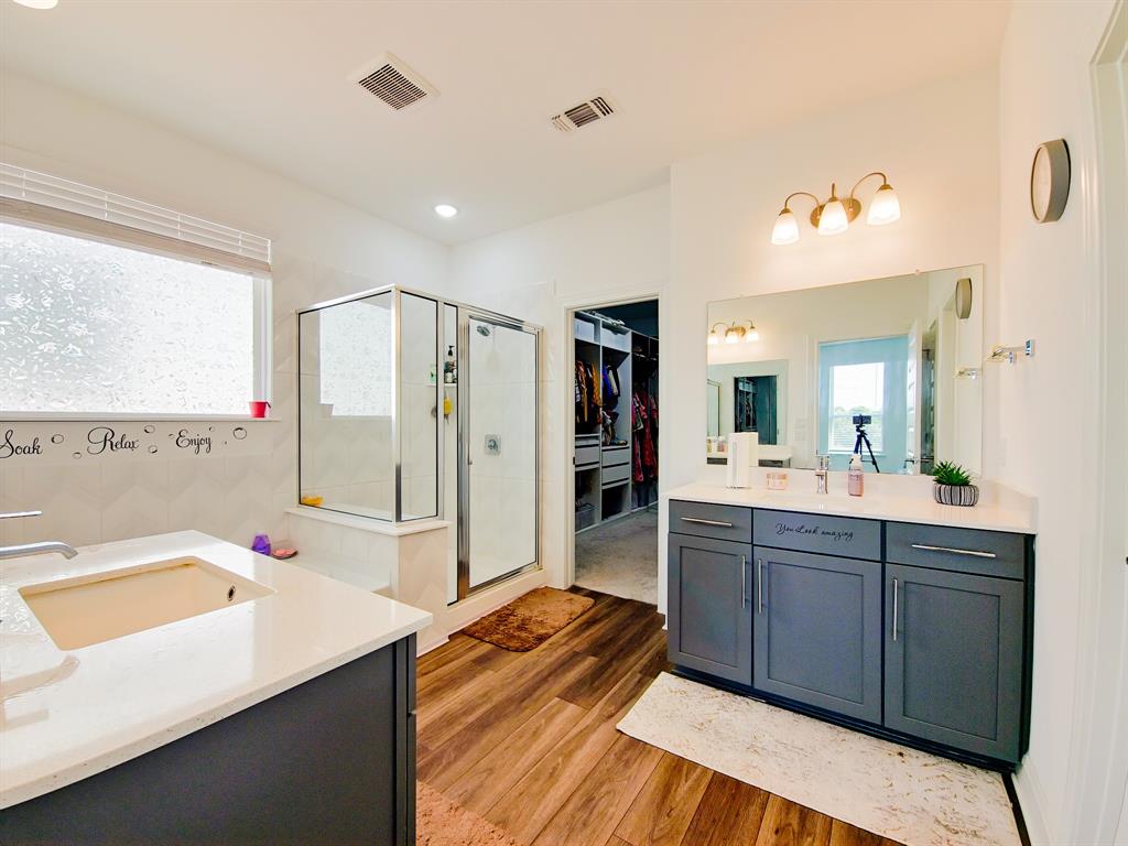 332 Turnbuckle Bend Leander, TX 78641 - Photo 20 of 34 Bathroom featuring wood-finish flooring and a glass-enclosed shower