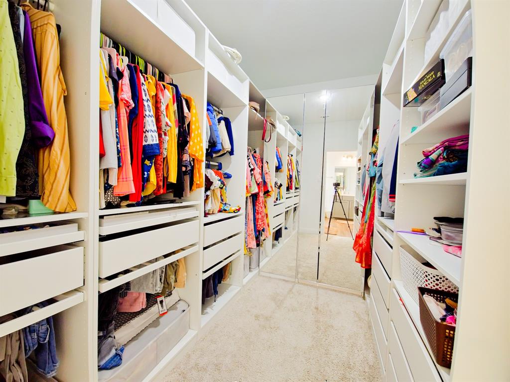 332 Turnbuckle Bend Leander, TX 78641 - Photo 26 of 34 Expansive custom closet featuring built-in shelving, multiple hanging rods, integrated drawers, and full-length mirrored panels