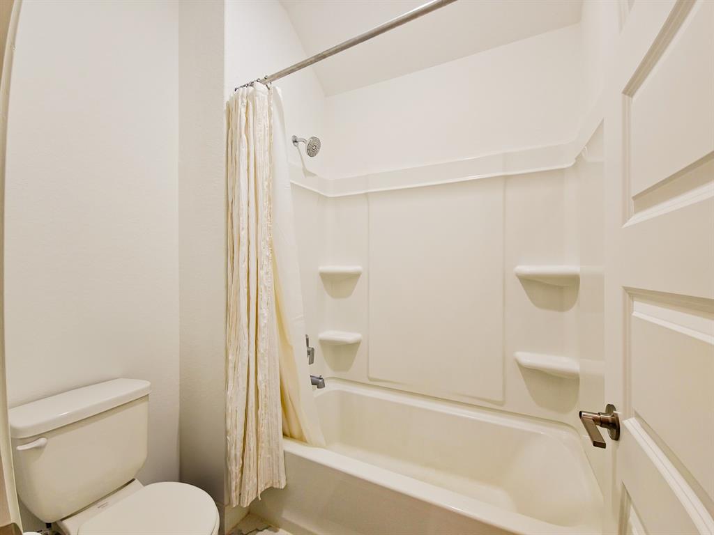332 Turnbuckle Bend Leander, TX 78641 - Photo 31 of 34 Full bathroom featuring a white tub/shower combination with integrated shelving, a polished chrome showerhead, and a white toilet