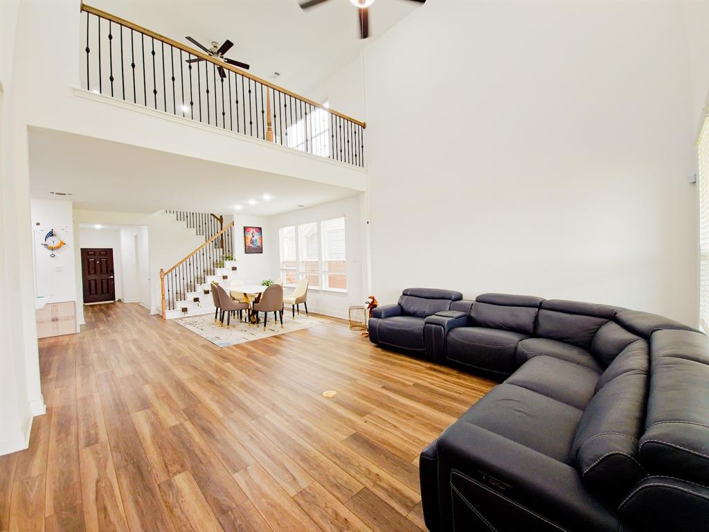332 Turnbuckle Bend Leander, TX 78641 - Photo 4 of 34 Two-story living area featuring wood-finish flooring throughout, a vaulted ceiling, and an open-concept layout