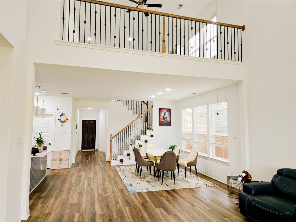 332 Turnbuckle Bend Leander, TX 78641 - Photo 6 of 34 Two-story foyer featuring wood-finish flooring, a contemporary staircase with wood handrails and wrought iron balusters, and a second-story overlook with matching balusters
