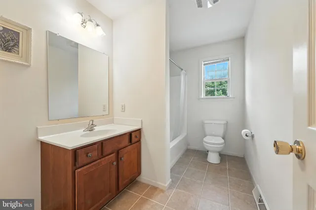 a spacious bathroom with a toilet sink and mirror