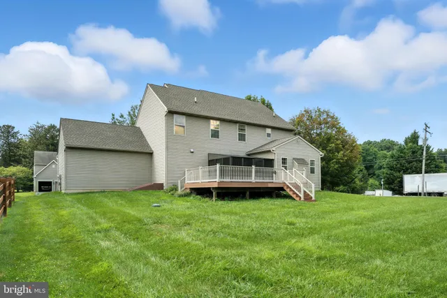 a view of a house with a big yard and a large tree