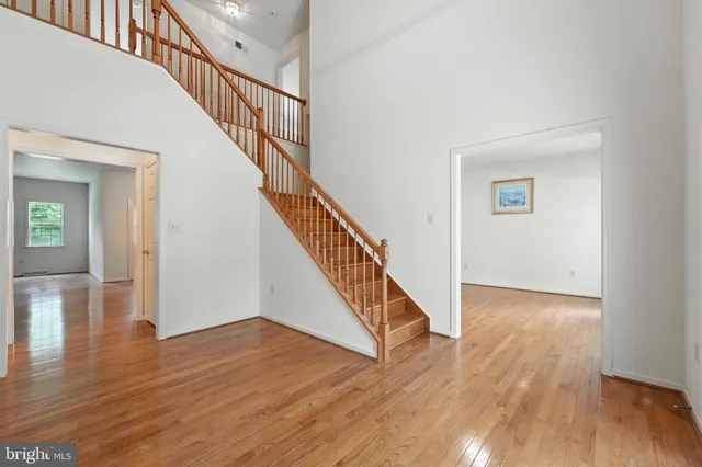 a view of staircase with wooden floor and white walls
