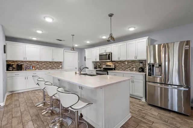 a kitchen with white cabinets and stainless steel appliances