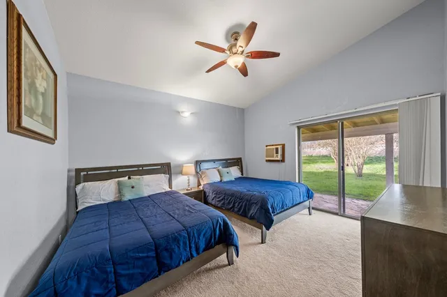 a bedroom with two large bed and a large window