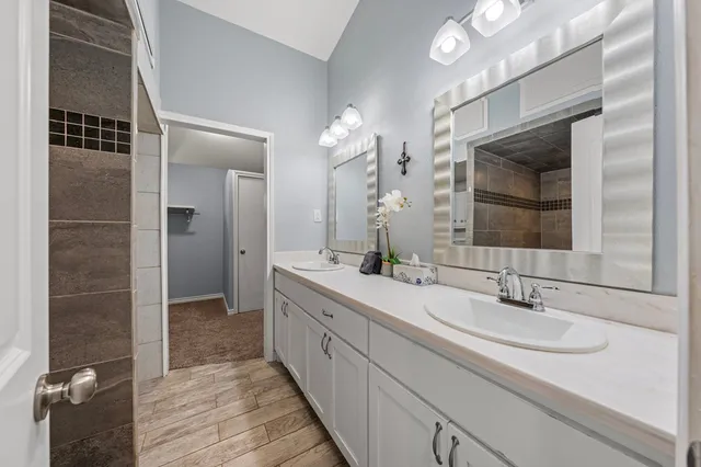 a bathroom with a double vanity sink and a mirror