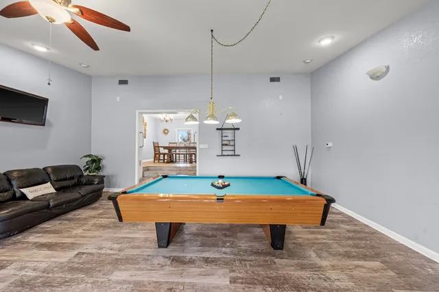 a room with furniture pool table and flat screen tv