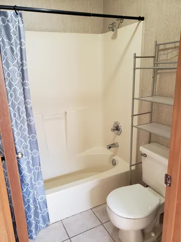 a bathroom with a toilet and a shower