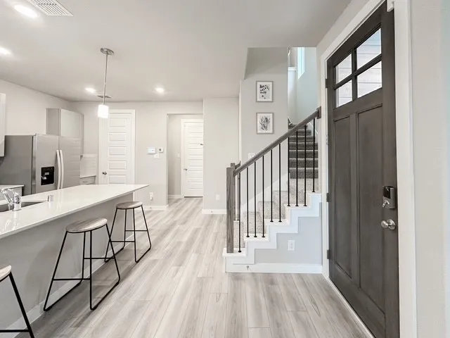 a view of a hallway with wooden floor and staircase