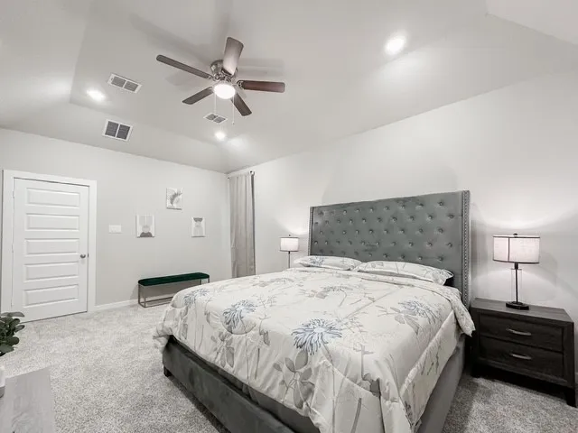 a bedroom with a bed and a ceiling fan