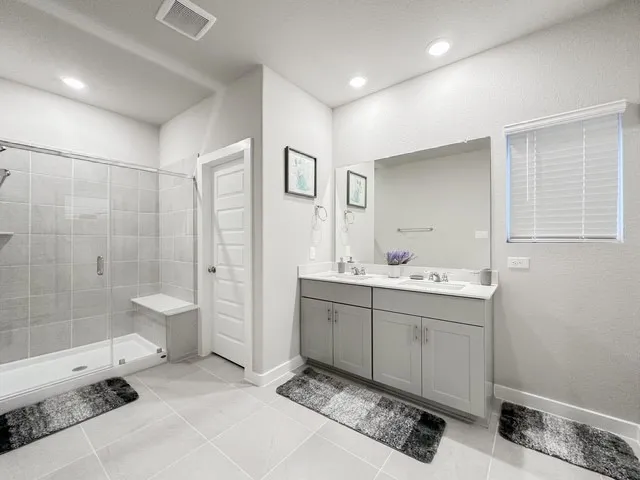 a spacious bathroom with a shower sink and mirror