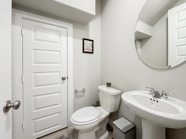 a bathroom with a sink toilet and a mirror