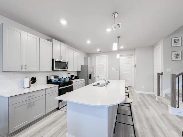 a kitchen with stainless steel appliances a sink stove and refrigerator
