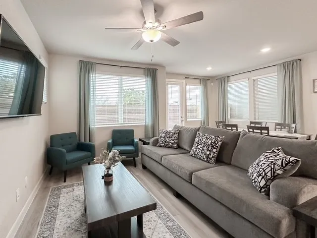 a living room with furniture ceiling fan and a window