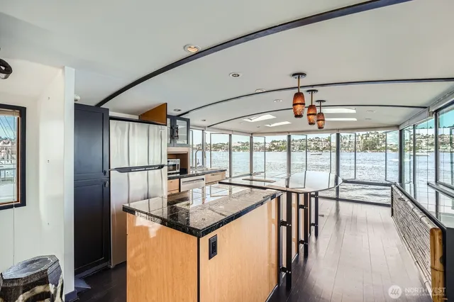 a view of an empty room with wooden floor and windows