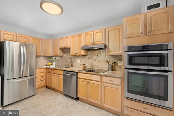 a kitchen with stainless steel appliances a stove refrigerator sink and microwave