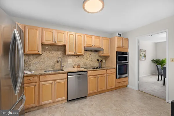 a kitchen with stainless steel appliances granite countertop a stove a sink and a refrigerator