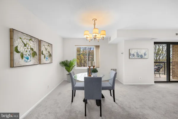 a view of a dining room with furniture and a chandelier