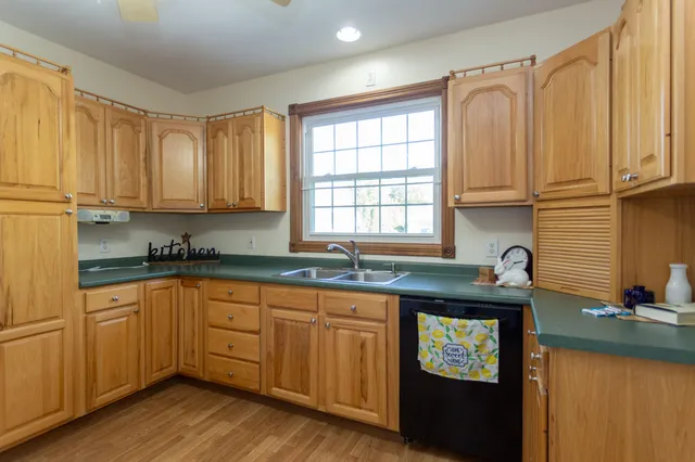 a kitchen with granite countertop a sink stove and cabinets